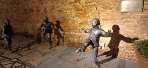 Statues of three kids sporting Chinese Ching Dynasty hairstyles, playing shuttle cock.