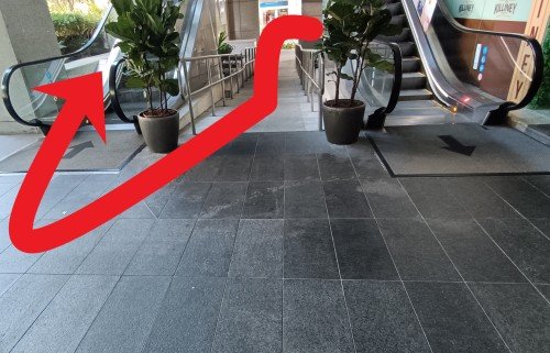 Turn left and go up the slope and make a right U-turn to go up the escalator.